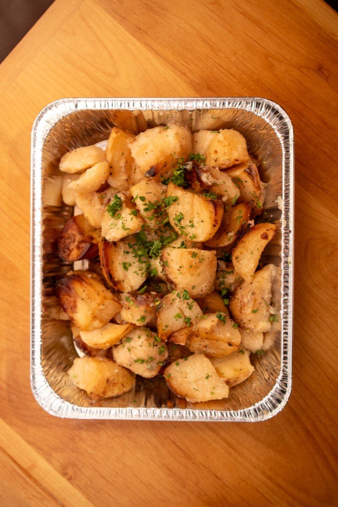Catering tray of roasted potatoes with parsley